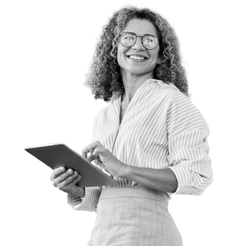 A woman in business casual. She wears glasses. She smiles as she holds a tablet.